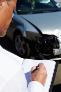 Loss Adjuster Inspecting Car Involved In Accident